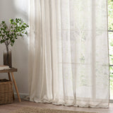 Nimbus Plain Polyester Curtain Panel in natural, sheer tie-top fabric hanging at a bright window beside a wooden side table and potted plant.
