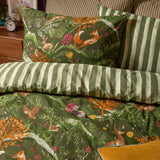 Nya Woodland Reversible Striped Duvet Cover Set in Forest, showing the woodland fox and hare print pillowcase paired with the reverse green striped side on a bedroom bed.