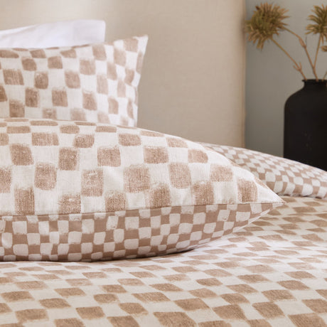 Nyhavn Reversible Check Duvet Cover Set in Tobacco, shown on a bed with matching pillowcases in tan and off-white checkerboard print, styled in a neutral bedroom setting.