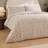 Nyhavn Reversible Check Duvet Cover Set in Tobacco, shown on a bed with matching pillowcases in a tan and off-white checkerboard pattern, styled in a bedroom setting with wooden flooring.