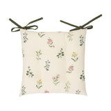 Olivia Linen Cotton Seat Pad in cream with pink, yellow and blue floral sprig print, tufted cotton cushion with green tie fastenings, shown on a plain white background.