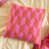 Olsen Geometric Polyester Cushion in Pink Pop, a square scatter cushion with a bold hot pink and rust chevron pattern, shown on striped bedding.