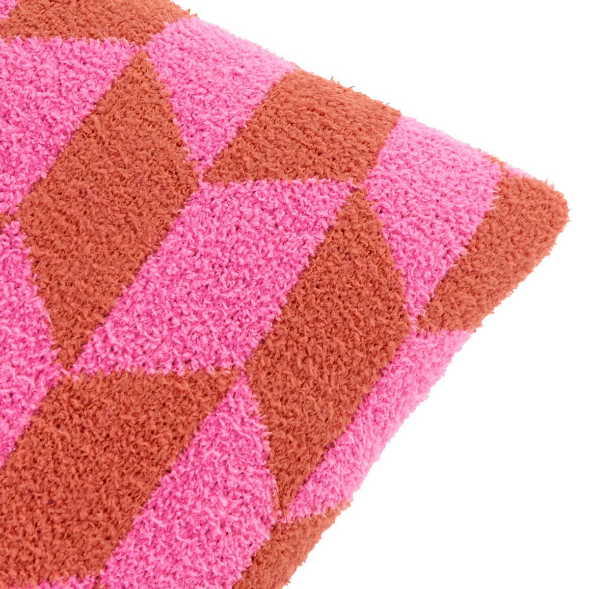 Close-up of the Olsen Geometric Polyester Cushion in Pink Pop, showing a textured high-loft knit fabric with an interlocking triangle pattern in hot pink and rust on a plain white background.