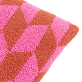 Close-up of the Olsen Geometric Polyester Cushion in Pink Pop, showing a textured high-loft knit fabric with an interlocking triangle pattern in hot pink and rust on a plain white background.