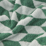 Olsen Geometric Polyester Throw in Good For You Green, close-up of the knitted feather-yarn fabric showing a bold triangular pattern in two greens against pale mint, softly draped in folds.
