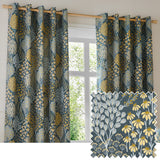 Ophelia Jacquard eyelet curtains in blue and saffron, hung on a wooden pole by a window, showing a woven floral tree and daisy pattern with a fabric swatch inset.