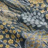 Close-up of Ophelia jacquard eyelet curtain fabric, showing woven saffron yellow and pale grey floral trees and daisies on a deep blue-teal ground.