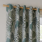 Ophelia Jacquard eyelet curtains in Thyme/Mineral, fully lined with a woven floral pattern in blue-green and forest tones on cream, hung on a wooden pole by a window.