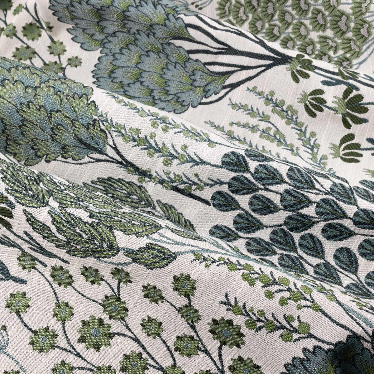 Close-up of Ophelia Jacquard Eyelet Curtains fabric, showing a woven floral pattern of stems, seed heads and flower clusters in blue-green and forest tones on a cream ground.