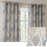 Ophelia Jacquard fully lined eyelet curtains in Wedgewood, hung on a wooden pole, featuring a woven floral tree and daisy pattern in slate blue, gold and taupe on a pale ground.