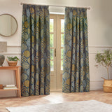 Ophelia Jacquard pencil pleat curtains in blue and saffron, woven botanical pattern, hung either side of French doors in a living room.