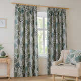 Ophelia Jacquard pencil pleat curtains in Thyme/Mineral, hung on a wooden pole, featuring a botanical tree and foliage pattern in green and blue-grey on cream in a living room.