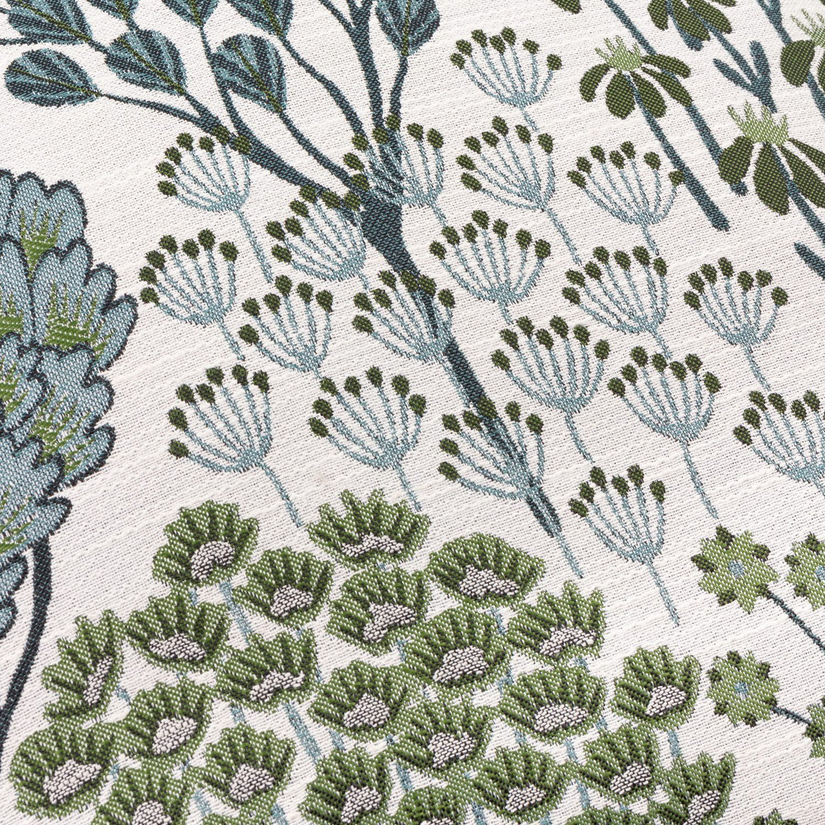 Close-up of the Ophelia Jacquard Polyester Cushion in Thyme/Mineral, showing raised woven botanical motifs of trees, seed heads and star flowers in green and blue-teal on a cream ground.