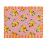 Rectangular pink polyester placemat with a digitally printed orange fruit and green leaf pattern, bordered on two sides by orange and pink stripes, shown on a plain white background.
