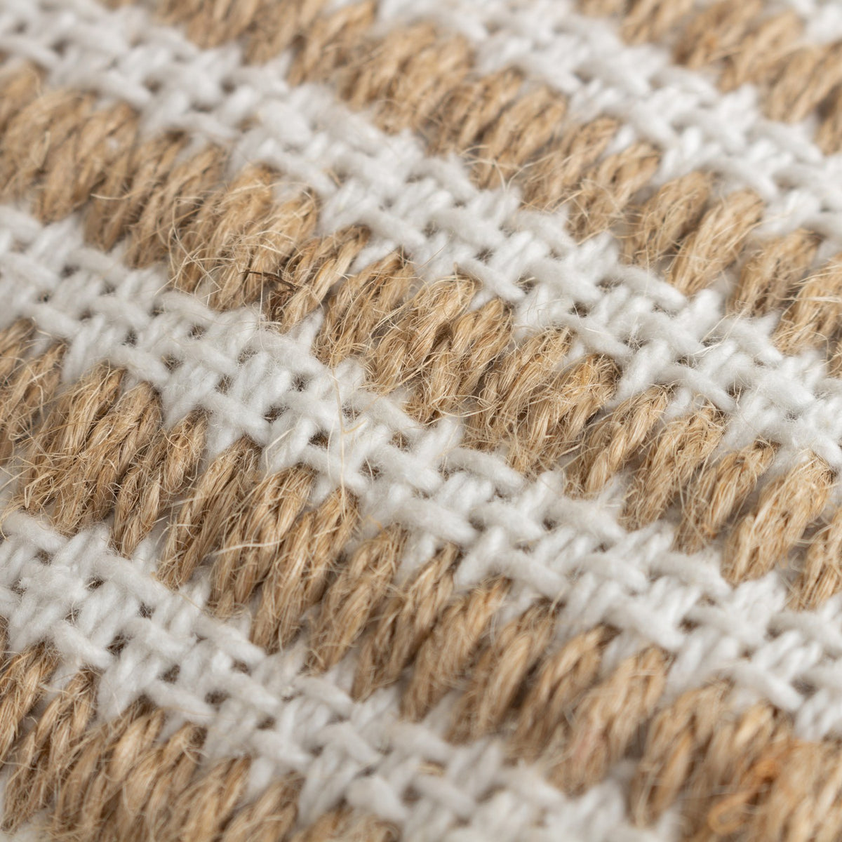 Close-up of the Organik Plain Cotton Cushion in natural, showing woven bands of coarse sandy jute alternating with rows of soft white cotton for a textured striped surface.