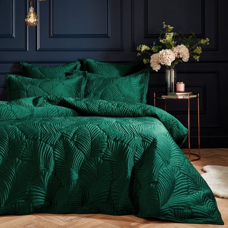 Palmeria Velvet Jungle Duvet Cover Set in emerald, showing a quilted palm-leaf pattern on velvet with matching pillowcases, styled on a bed against a dark panelled wall.