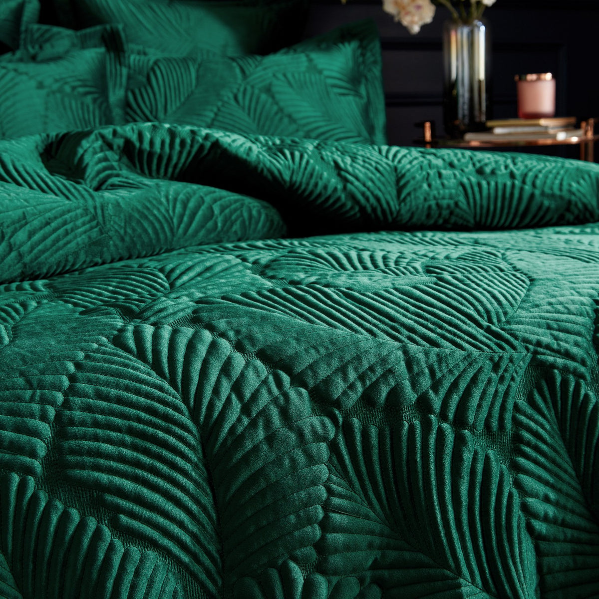Palmeria Velvet Jungle Duvet Cover Set in emerald green, quilted palm-leaf pattern raised on velvet fabric, styled on a bed with matching pillowcases in a dark bedroom setting.