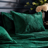 Palmeria Velvet Jungle Duvet Cover Set in emerald, showing quilted palm-leaf embroidered velvet pillowcases and duvet on a bed in a dark bedroom setting.