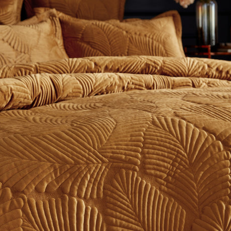 Palmeria Velvet Jungle Duvet Cover Set in gold, quilted palm-leaf pattern on velvet fabric, shown on a dressed bed with matching pillowcases.