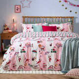 Passport To The North Pole Striped Duvet Cover Set in Candy Floss/Linen, shown on a bed with Santa scenes on pink and cream stripes, styled with green and pink cushions in a festive bedroom.