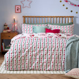 Passport To The North Pole striped duvet cover set on a bed, showing the red and pink mistletoe stripe design with pillowcases in a festive bedroom setting.