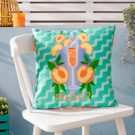 Peachy Abstract Polyester Cushion in aqua on a white outdoor chair, featuring a wavy stripe print, Bellini glass, peaches, green leaves and coral "Peachy?" text.