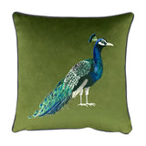 Square olive green velvet cushion with grey piped edge, featuring a printed peacock in profile with blue-green plumage and a long detailed tail, shown on a white background.
