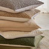 Pebble Linen Chenille Cushion in stone, shown stacked with coordinating textured cushions in taupe, beige, and olive tones with linen piping detail.