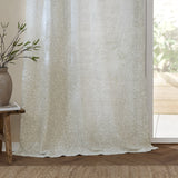 Perrie Leaf Floral Polyester Curtain Panel in natural, semi-sheer fabric with a small trailing leaf print, hung by a bright glass door in a living room setting.