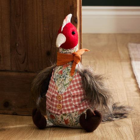 Bird-shaped fabric door stop with red felt head, floral jacket over pink gingham waistcoat, rust-orange scarf and grey feathery tail.