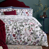 Off-white Pick Your Poison duvet cover set with pink, purple, green and red botanical florals and apothecary bottle print, styled with burgundy velvet cushions and a throw.