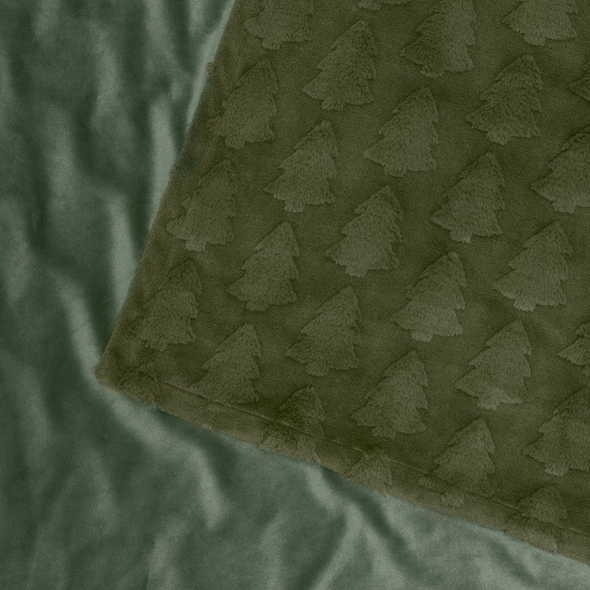 Pines Velvet Faux Fur Throw in forest green, showing raised tufted tree pattern on one side and plain smooth velvet reverse, folded corner detail.