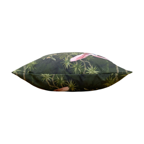 Side view of the Platalea Jungle polyester cushion in bottle green, showing a hand-illustrated tropical scene with pink spoonbills among palms, photographed against a plain white background.