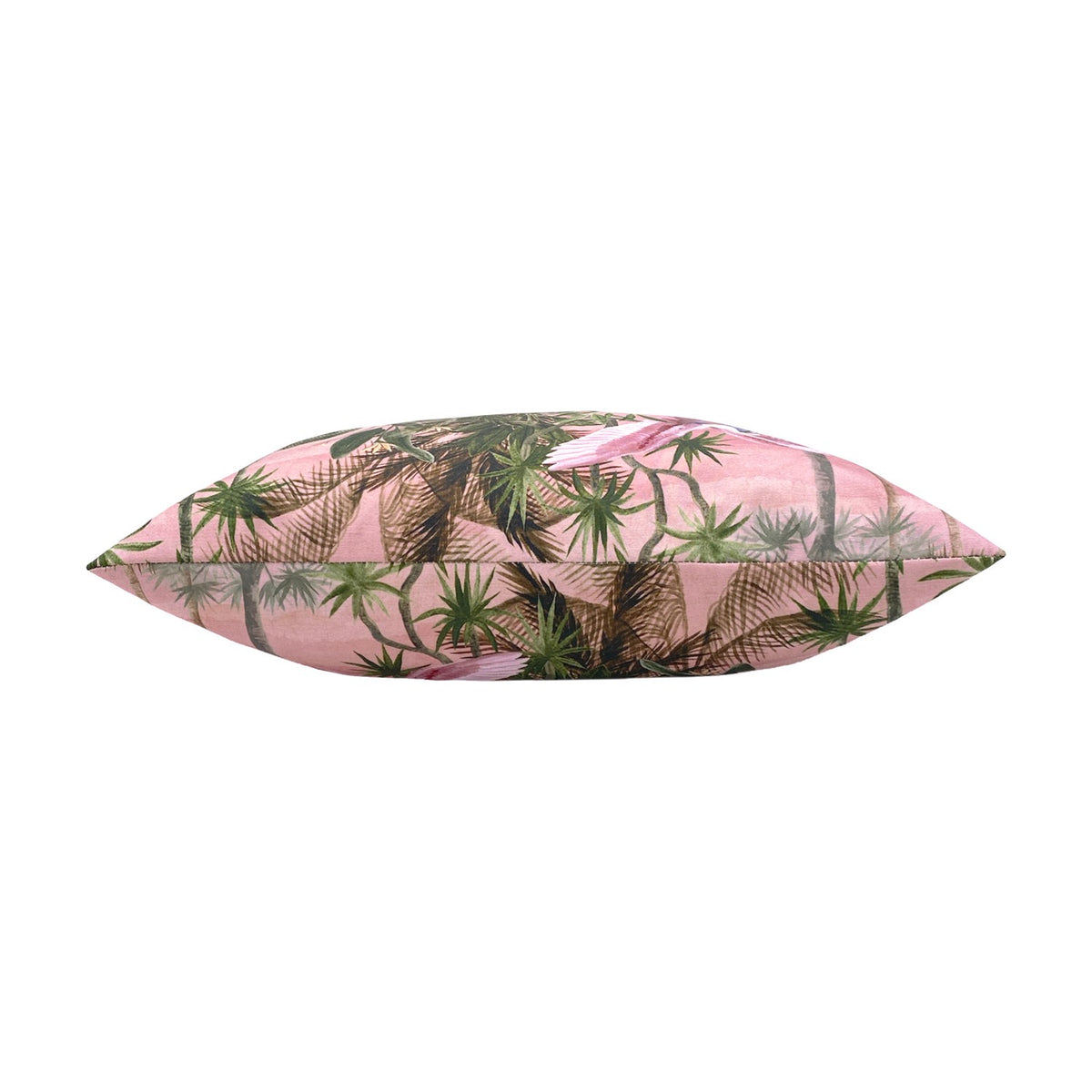 Platalea Jungle polyester cushion in Blush, shown side-on to reveal its plump piped edge printed with palms and wading birds on pink, set against a white background.