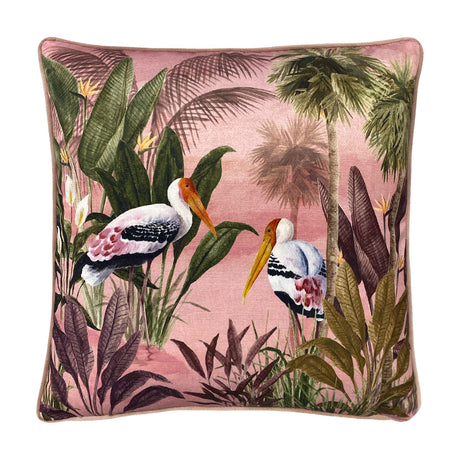 Platalea Botanical Velvet Cushion in pink, square with piped edge, featuring a painted scene of two Spoonbill birds among palms and jungle leaves on a blush ground, shown on a white background.