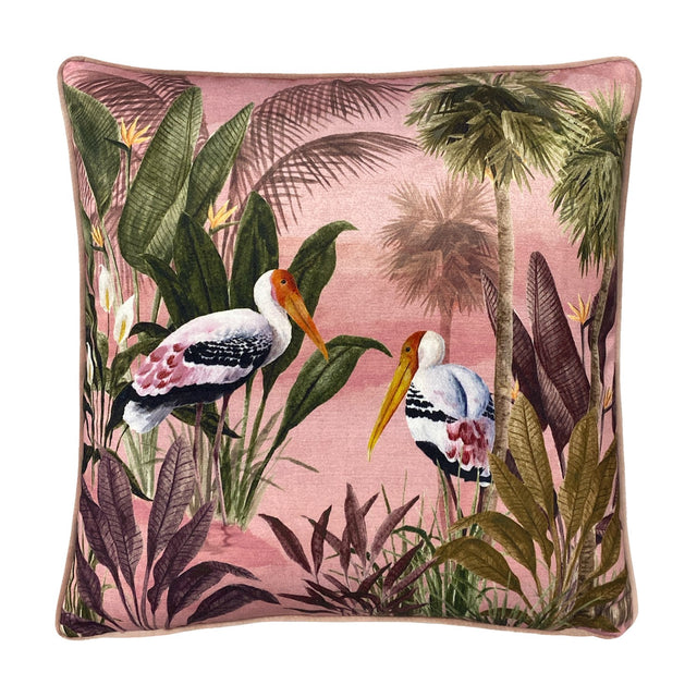Platalea Botanical Velvet Cushion in pink, square with piped edge, featuring a painted scene of two Spoonbill birds among palms and jungle leaves on a blush ground, shown on a white background.