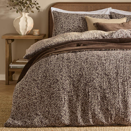 Perrie Leaf Cotton Ditsy Duvet Cover Set in chocolate brown with cream leaf print, shown on a bed with matching pillowcases in a bedroom setting.