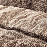 Close-up of the Perrie Leaf Cotton Ditsy Duvet Cover Set in chocolate brown, showing crinkled cotton texture with a small cream leaf print and reverse-side pattern.