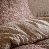Perrie Leaf Cotton Ditsy Duvet Cover Set in Cinnamon, showing cream leaf sprig print on layered cotton bedding with matching pillowcases on a bed.