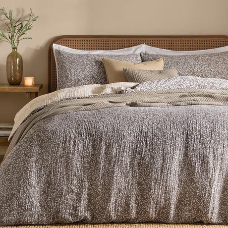 Perrie Leaf Cotton Ditsy Duvet Cover Set in Mole styled on a bed with matching pillowcases, crinkled cotton texture, and layered cushions and throws in a bedroom setting.