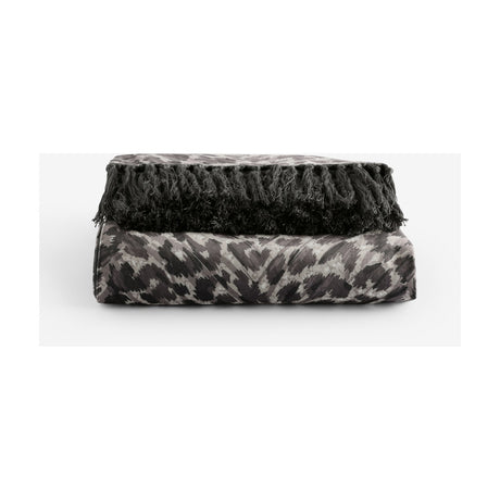 Pokot Animal Velvet Throw in monochrome, folded to show leopard-print grey and black velvet with knotted black fringe trim, on a plain white background.
