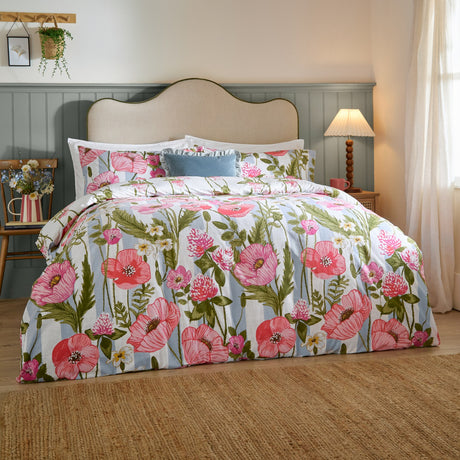 Poppy Trail Reversible Floral Duvet Cover Set in multi pink and green on a bedroom bed, with matching pillowcases and striped floral fabric against a grey panelled wall.