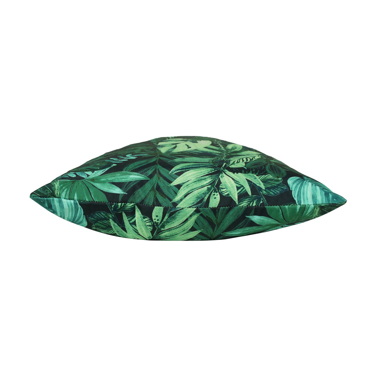 Side view of the Psychedelic Jungle Reversible Polyester Cushion, showing a dense tropical leaf print in green and blue-green tones on a near-black ground, photographed on a plain white background.