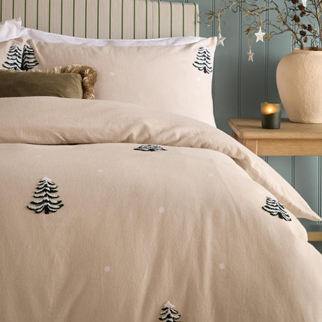 Pine Tree Cotton Woodland Duvet Cover Set in natural, styled on a bed with matching pillowcases showing tufted fir tree motifs and scattered dot detailing in a bedroom setting.