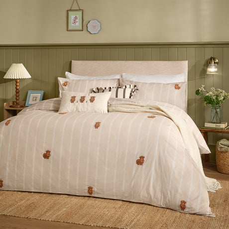 Ramble Cotton Embroidered Duvet Cover Set in natural beige with vertical stripes and tufted highland cow motifs, styled on a bed in a green-panelled bedroom.