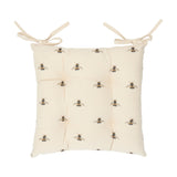 Square tufted seat pad in natural cotton with a bumble bee print, buttoned centre, and two fabric ties at the top corners, shown on a plain white background.