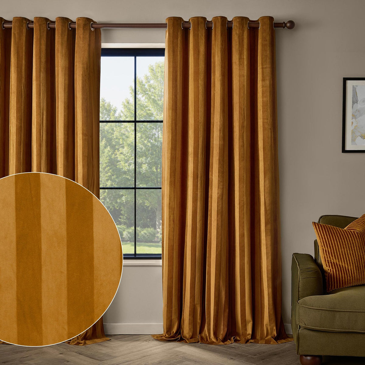 Regency Stripe Velvet Fully Lined Eyelet Curtains in antique gold, shown floor-to-ceiling either side of a window in a living room with a green sofa and striped cushion.