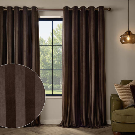 Regency Stripe Velvet Fully Lined Eyelet Curtains in chocolate brown, shown hanging on a bronze rod beside a window, with a fabric swatch inset showing the vertical tonal stripe.