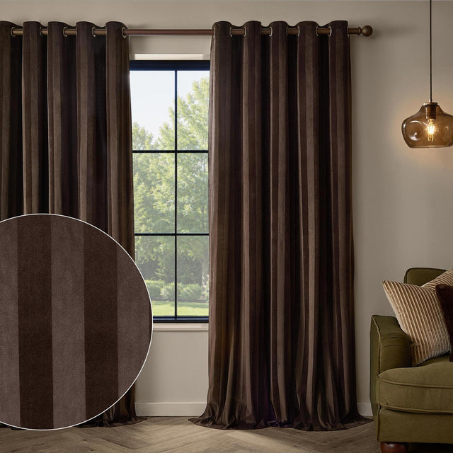 Regency Stripe Velvet Fully Lined Eyelet Curtains in chocolate brown, shown hanging on a bronze rod beside a window, with a fabric swatch inset showing the vertical tonal stripe.
