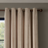 Regency Stripe Velvet Eyelet Curtains in beige with subtle self-stripe pile, fully lined, hung with eyelet header on a wooden pole against a neutral wall.